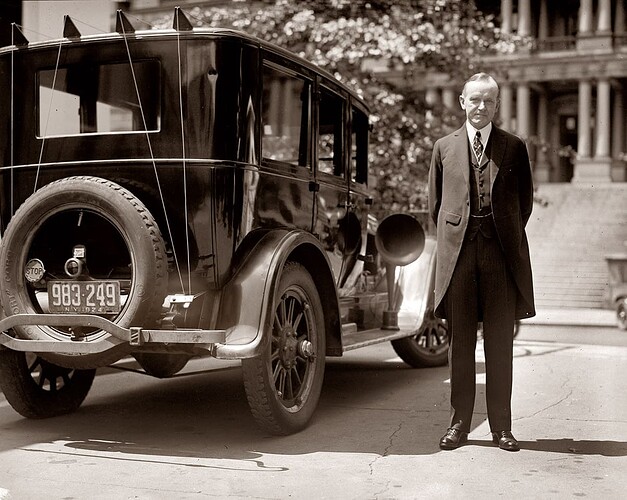 President Calvin Coolidge in New York standing beside a Buick Sedan with New York plates. Note radio aerial wires on back of car and loud-speaker on the running board. The radio was installed by RCA