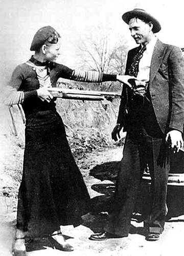Bonnie and Clyde goof around with a rifle. The outlaws left a camera with a number of photos like this at a crime scene, feeding the appetite of newspaper readers following their crime spree.