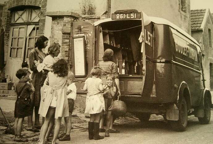 Housewives pick up wine from a local delivery van in post-war France 1950s