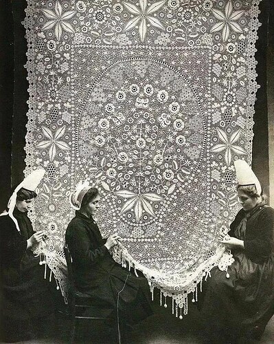 Three lacemakers meticulously working on delicate lace in Brittany, France, 1920. Their skilled hands weave intricate patterns, continuing a centuries-old tradition of craftsmanship in the region.