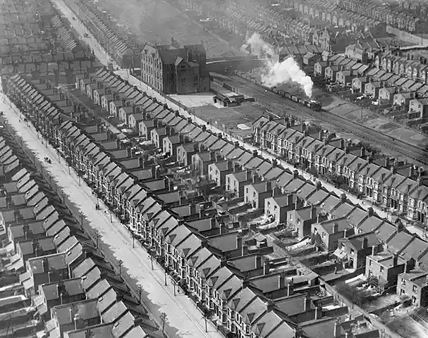 A train passes through densely packed housing along Kensal Rise, London, England, in March 1921. This scene captures the rapid urbanization of London during the early 20th century